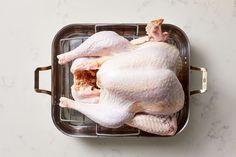 a whole chicken sitting in a pan on a counter