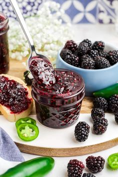 a spoon full of jam sitting on top of a cutting board next to sliced green peppers