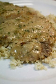 a white plate topped with rice and meat covered in gravy