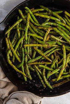 asparagus being cooked in a skillet on top of a towel and cloth