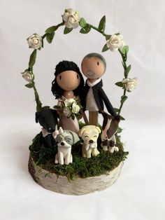 a wedding cake topper with two people and dogs in front of a circular frame