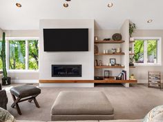 a living room with couches and a television mounted on the wall above a fireplace