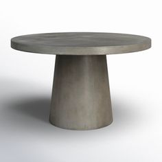 a round concrete table sitting on top of a white floor