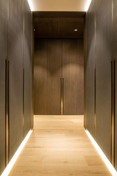 an empty hallway with wooden doors and lights