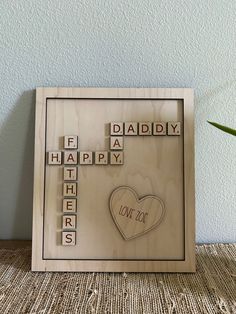 a wooden scrabble frame with the words happy father's day on it