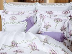 a bed with purple flowers and white sheets