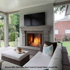 an outdoor living room with a fireplace and television