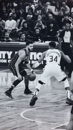 two men playing basketball in front of an audience