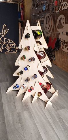 a christmas tree made out of wine bottles is on the floor in front of a wall