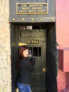 a woman standing in front of a black door