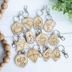 a bunch of wooden keychains sitting on top of a table next to a plant