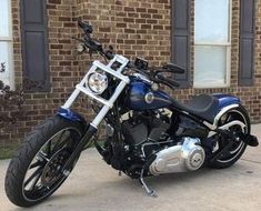 a blue motorcycle parked in front of a brick building