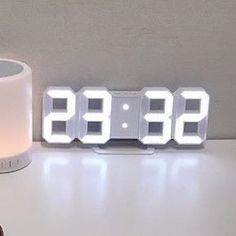 an alarm clock sitting on top of a white table