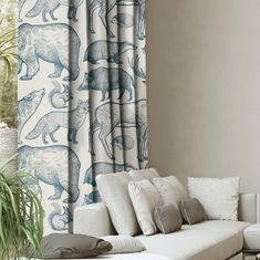 a living room filled with furniture and a large window covered in blue animal print curtains