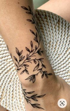 a black and white photo of a woman's foot with leaves on it,