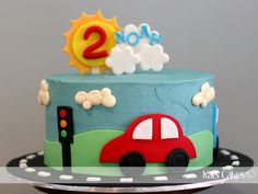 a birthday cake decorated with a car and the number two on it's top