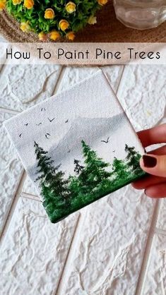 someone is painting pine trees on paper and then they are painted with acrylic paint