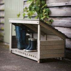 a pair of rain boots sitting in a wooden crate on the ground next to a building