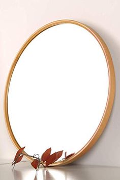 a round mirror sitting on top of a table next to a wall mounted planter