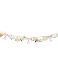 a garland with flowers and ribbons hanging from it's sides on a white background