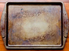 an old metal tray sitting on top of a wooden table