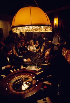 a group of people playing roulege in a dark room