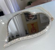 a heart shaped mirror sitting on top of a table