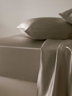 the sheets and pillow cases are made up in two different shades of gray, white or beige