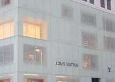 the building is white and has windows on each side that say louis vuitton