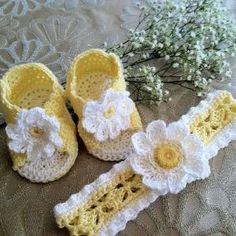 two crocheted baby shoes with flowers on them