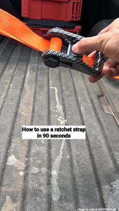 a hand holding an orange strap in the back of a truck with text reading how to use a ratchet strap in 90 seconds