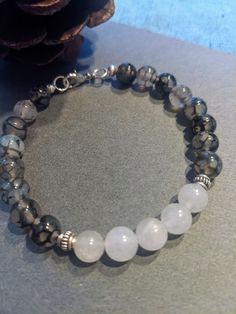 Gray and white Chakra beaded bracelet.  Very comfortable. # 125 Casual Silver Bracelets With Gemstone Beads, Casual White Crystal Bracelet, Gray Adjustable Bracelets With Faceted Beads, Adjustable Gray Bracelets With Faceted Beads, Adjustable Gray Bracelet With Faceted Beads, Casual White Hand-strung Crystal Bracelet, White Crystal Bracelet With Faceted Beads, White Faceted Beads Crystal Bracelet, Handmade White Crystal Round Bracelet