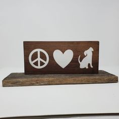 a wooden sign with peace, love and a dog