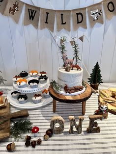 a table topped with cakes and cupcakes on top of wooden letters that spell out wild