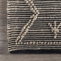 a black and white rug on top of a wooden floor