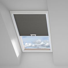 an empty room with a skylight in the corner and blinds on the window sill