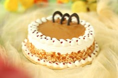 a cake with white frosting and brown decorations on it's top sitting on a table