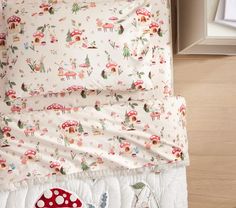 a bed with a mushroom print comforter and matching pillow cases on top of it