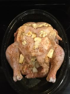 a whole chicken sitting in the middle of an oven with garlic and seasoning on it