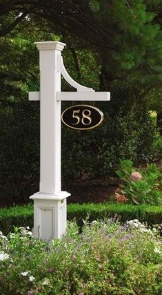 a white cross with the number sixty on it in front of some bushes and trees