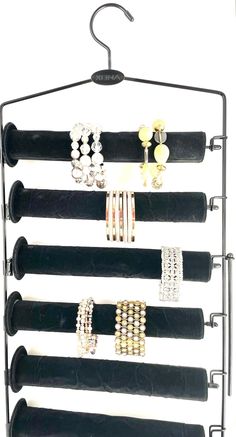 a rack with several pairs of bracelets and rings hanging from it's sides