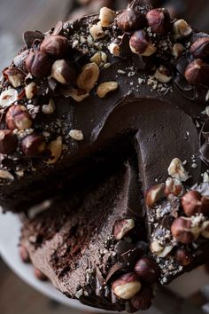 a chocolate cake with nuts on top is cut in half and ready to be eaten