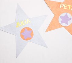 two star shaped stickers with the words julia and peter written on them, sitting next to each other