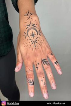 a woman's hand with tattoos on it, and the fingers are decorated with stars