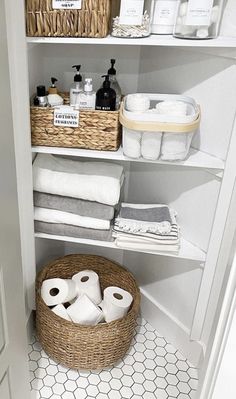 an organized bathroom with toilet paper and baskets