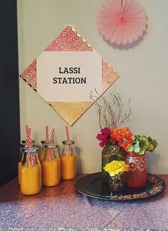 a table topped with vases filled with orange juice and jars next to each other