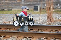 a little boy that is standing on some train tracks