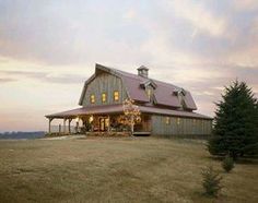 a barn with a pink roof and lights on it