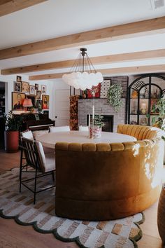 a large round table in the middle of a living room with chairs and rugs