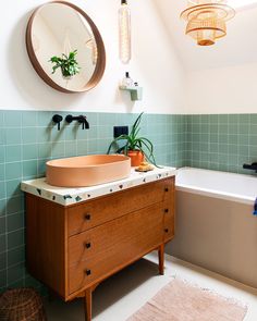 a bathroom with a sink, mirror and bathtub in the middle of the room